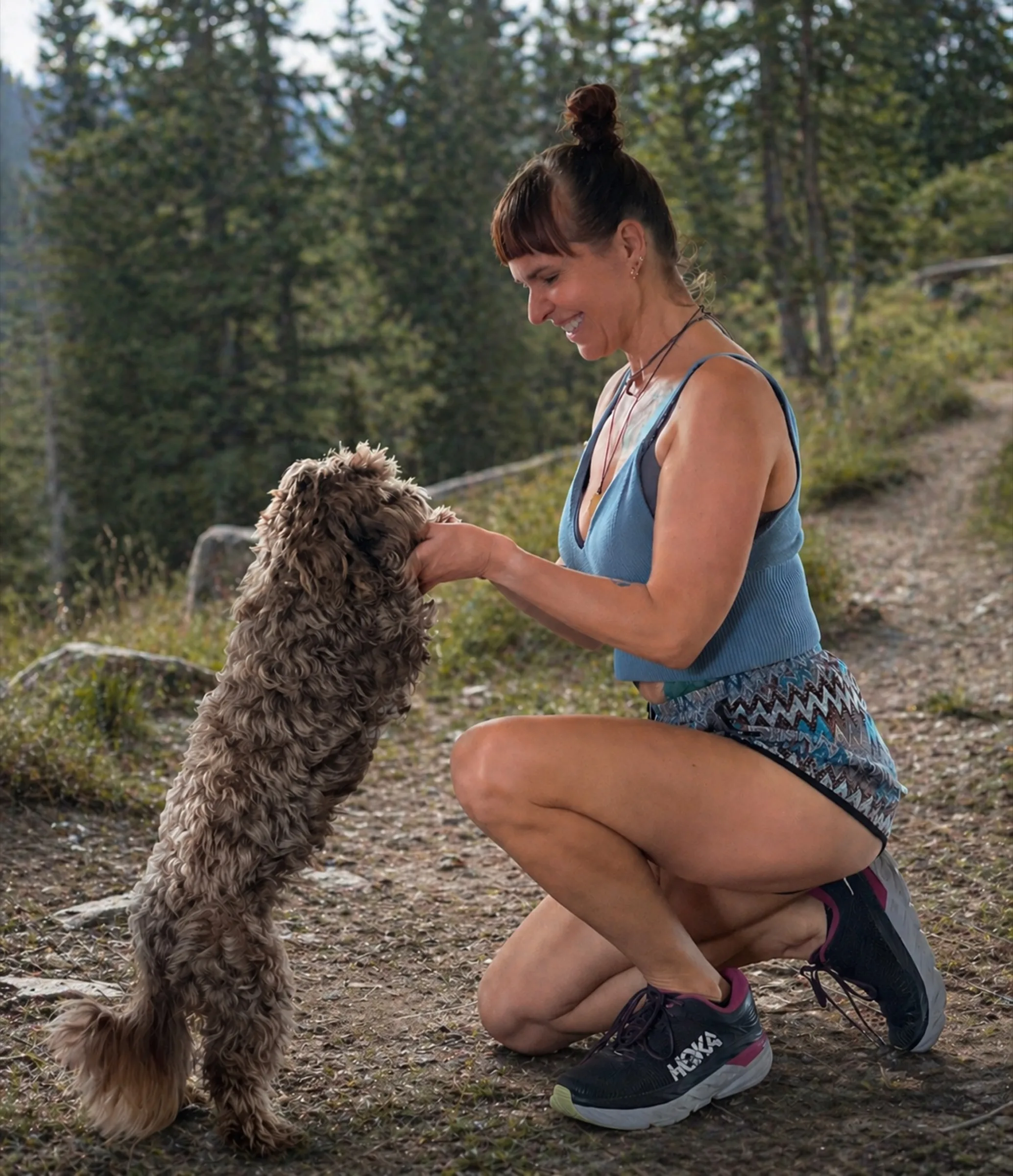 Trainerin mit kleinem Hund in der Natur Mallorcas, ruhige Nahaufnahme.